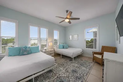 a bedroom with two beds and a ceiling fan at The Sassy Seagull - 30A Beach House with Ocean Views in Seacrest