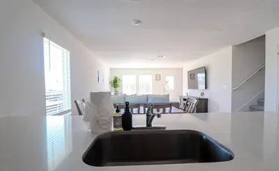 a kitchen sink with a bottle of wine on a counter at Cozy 4BR Panama City Retreat! Games & Beach Gear! in Panama City
