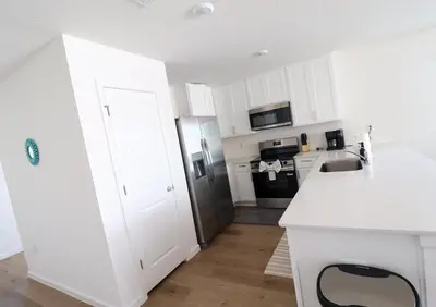 a kitchen with white cabinets and a stainless steel refrigerator at Cozy 4BR Panama City Retreat! Games & Beach Gear! in Panama City