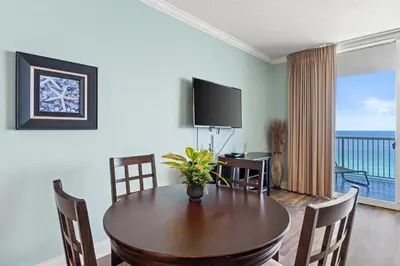 a dining room with a table and a television at Palazzo Beach Resort by Panhandle Getaways in Panama City Beach