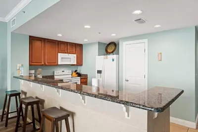 a kitchen with a counter and a refrigerator at Palazzo Beach Resort by Panhandle Getaways in Panama City Beach