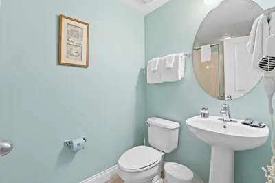 a bathroom with a toilet and a sink and a mirror at Palazzo Beach Resort by Panhandle Getaways in Panama City Beach