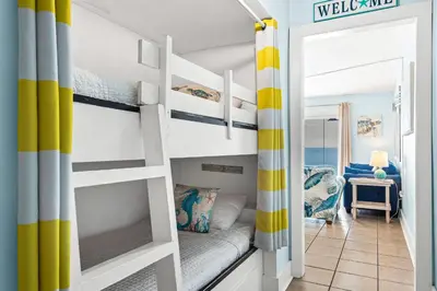 a room with bunk beds and a living room at Summit 1417 Beach Resort - Amazing Balcony Views in Panama City Beach