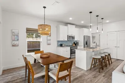a kitchen and dining room with a table and chairs at Beach House with Private Pool - Sunny Sands by Panhandle Getaways in Panama City
