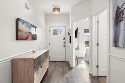a hallway with white walls and a door with a wooden table at Beach House with Private Pool - Sunny Sands by Panhandle Getaways in Panama City