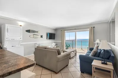 a living room with a couch and a tv at Summit 807 Beach Resort - Amazing Balcony Views in Panama City Beach