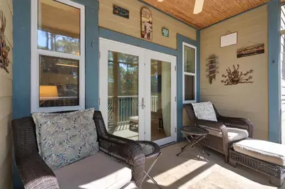 a porch with two wicker chairs and a porch swing at 30A-Sea La Vie-Seagrove Highlands 2302 in Santa Rosa Beach