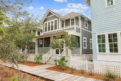 a house with a white fence in front of it at Sea Glass Cottage by 30A Escapes in Watersound Beach