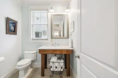 a bathroom with a sink and a toilet and a mirror at Sea Glass Cottage by 30A Escapes in Watersound Beach