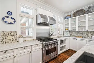 a kitchen with white cabinets and a stove top oven at Sea Glass Cottage by 30A Escapes in Watersound Beach