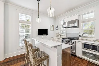 a kitchen with white walls and a stove top oven at Sea Glass Cottage by 30A Escapes in Watersound Beach