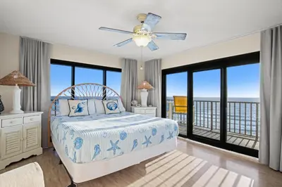 a bedroom with a bed with a view of the ocean at Commodore 0601 in Panama City Beach