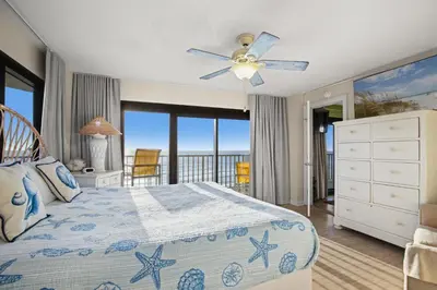a bedroom with a bed with a view of the ocean at Commodore 0601 in Panama City Beach