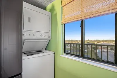 a laundry room with a washer and dryer and a window at Commodore 0601 in Panama City Beach