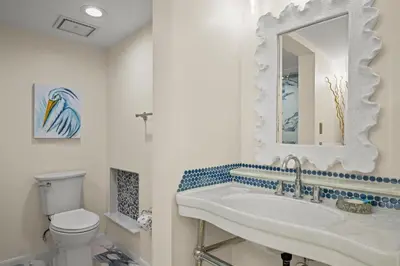a bathroom with a sink and a toilet and a mirror at Commodore 0601 in Panama City Beach