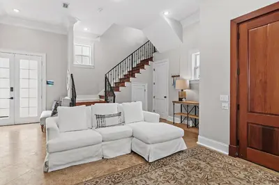 a living room with a white couch and a staircase at Villa Palmeira in Santa Rosa Beach