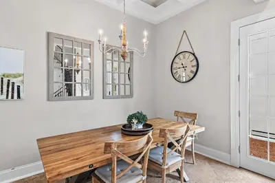 a dining room with a table and a clock on the wall at Villa Palmeira in Santa Rosa Beach