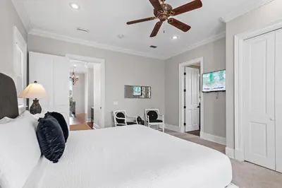 a bedroom with a white bed and a ceiling fan at Villa Palmeira in Santa Rosa Beach
