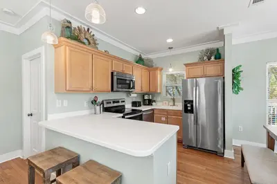 a kitchen with wooden cabinets and a refrigerator at Beach Therapy in Seacrest