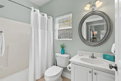 a bathroom with a toilet and a sink and a mirror at Beach Therapy in Seacrest