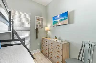 a bedroom with a bunk bed and a dresser and a bed at Beach Therapy in Seacrest