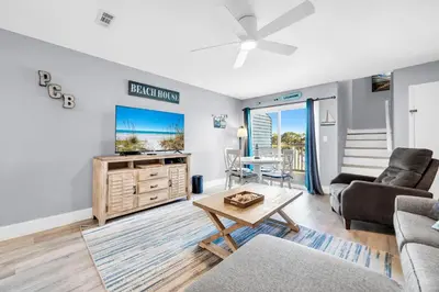 a living room with a couch and a tv and a table at Lullwater Beach 415 in Panama City Beach