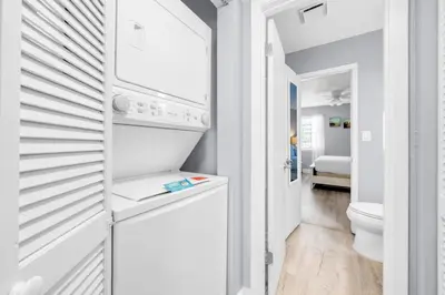 a white kitchen with a washer and dryer at Lullwater Beach 415 in Panama City Beach