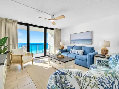 a living room with a blue couch and a view of the ocean at Edgewater Tower 3-1003 in Panama City Beach