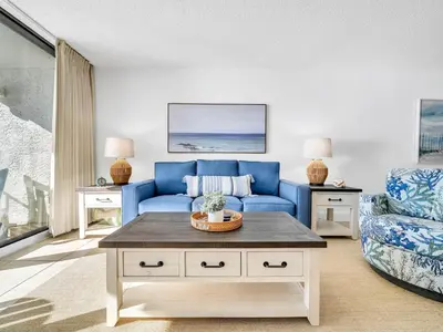 a living room with a blue couch and a chair at Edgewater Tower 3-1003 in Panama City Beach