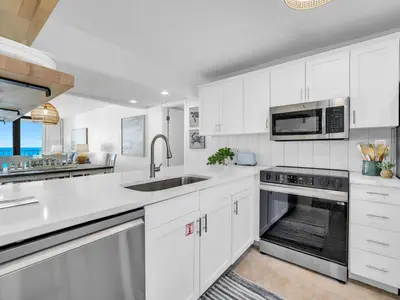 a white kitchen with a sink and a microwave at Edgewater Tower 3-1003 in Panama City Beach