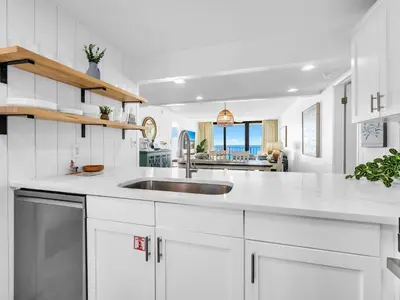 a kitchen with white cabinets and a sink at Edgewater Tower 3-1003 in Panama City Beach