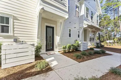 a white house with a porch and a driveway at Rhema Luxury Beach Haus 2BR 2B ResortPool with optional 6-seater GolfCart & 4Bikes in Inlet Beach