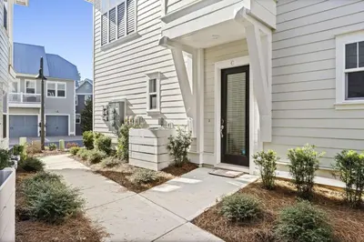 a white house with a door and a sidewalk at Rhema Luxury Beach Haus 2BR 2B ResortPool with optional 6-seater GolfCart & 4Bikes in Inlet Beach