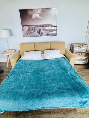 a bed with a blue blanket on top of it at PCB Beach Gateaway On The Sand in Panama City Beach