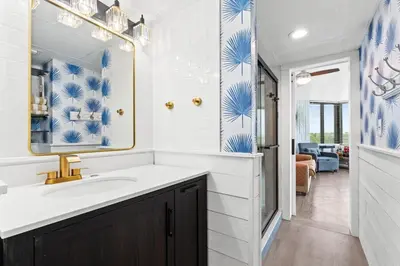 a bathroom with a sink and a mirror at PCB Beach Gateaway On The Sand in Panama City Beach