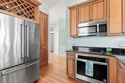a kitchen with stainless steel appliances and wooden cabinets at High Tide in Inlet Beach