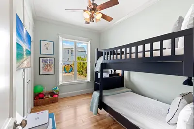 a bedroom with two bunk beds and a ceiling fan at High Tide in Inlet Beach