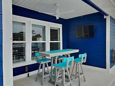 a blue room with a table and chairs at Nothin But Time in Panama City Beach