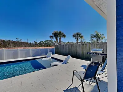a patio with chairs and a swimming pool at Nothin But Time in Panama City Beach