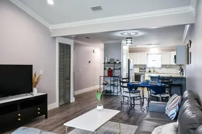 a living room with a couch and a table and a kitchen at Renovated Townhome by the Bay in Panama City