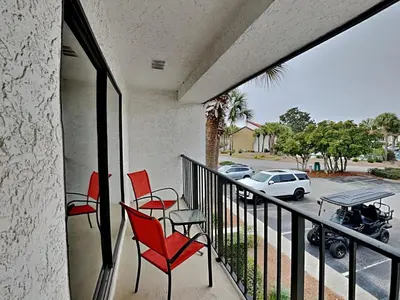 a balcony with red chairs and a view of a street at Edgewater Villa #2713 - The Palm and Pool Villa in Panama City Beach