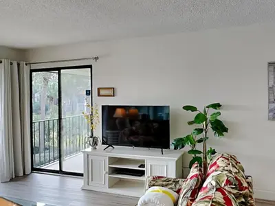 a living room with a couch and a flat screen tv at Edgewater Villa #2713 - The Palm and Pool Villa in Panama City Beach