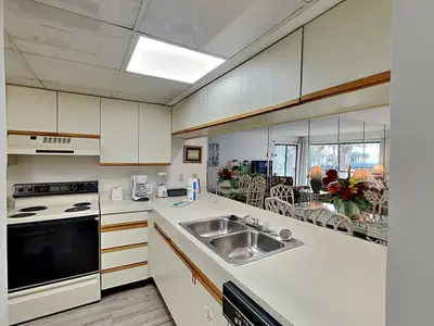 a kitchen with a sink and a stove top oven at Edgewater Villa #2713 - The Palm and Pool Villa in Panama City Beach