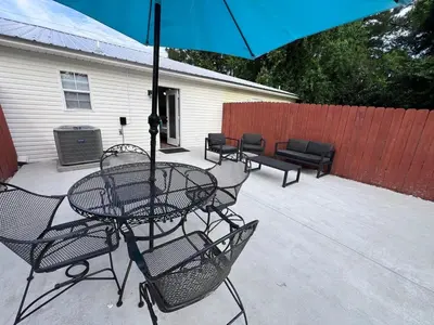 a table and chairs with an umbrella on a patio at First Cast in Panama City Beach