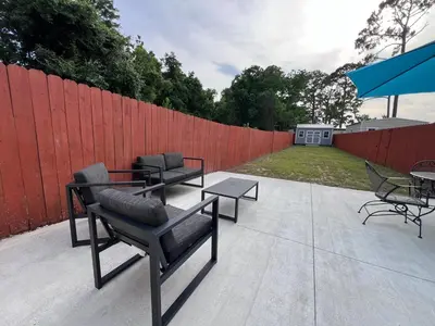 a patio with chairs and tables and a fence at First Cast in Panama City Beach
