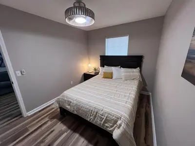 a bedroom with a bed and a pendant light at First Cast in Panama City Beach