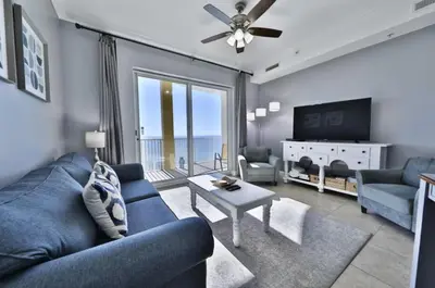 a living room with a blue couch and a tv at Ocean Ritz 2202 by Emerald Coast Retreats in Panama City Beach