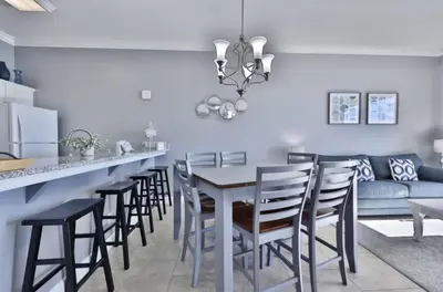 a kitchen and dining room with a table and chairs at Ocean Ritz 2202 by Emerald Coast Retreats in Panama City Beach