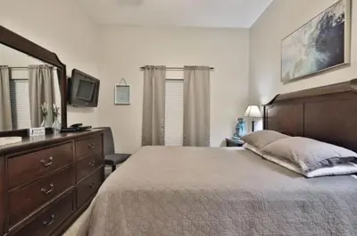 a bedroom with a bed with a dresser and a mirror at Ocean Ritz 2202 by Emerald Coast Retreats in Panama City Beach