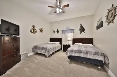 a bedroom with two beds and a ceiling fan at Ocean Ritz 2202 by Emerald Coast Retreats in Panama City Beach